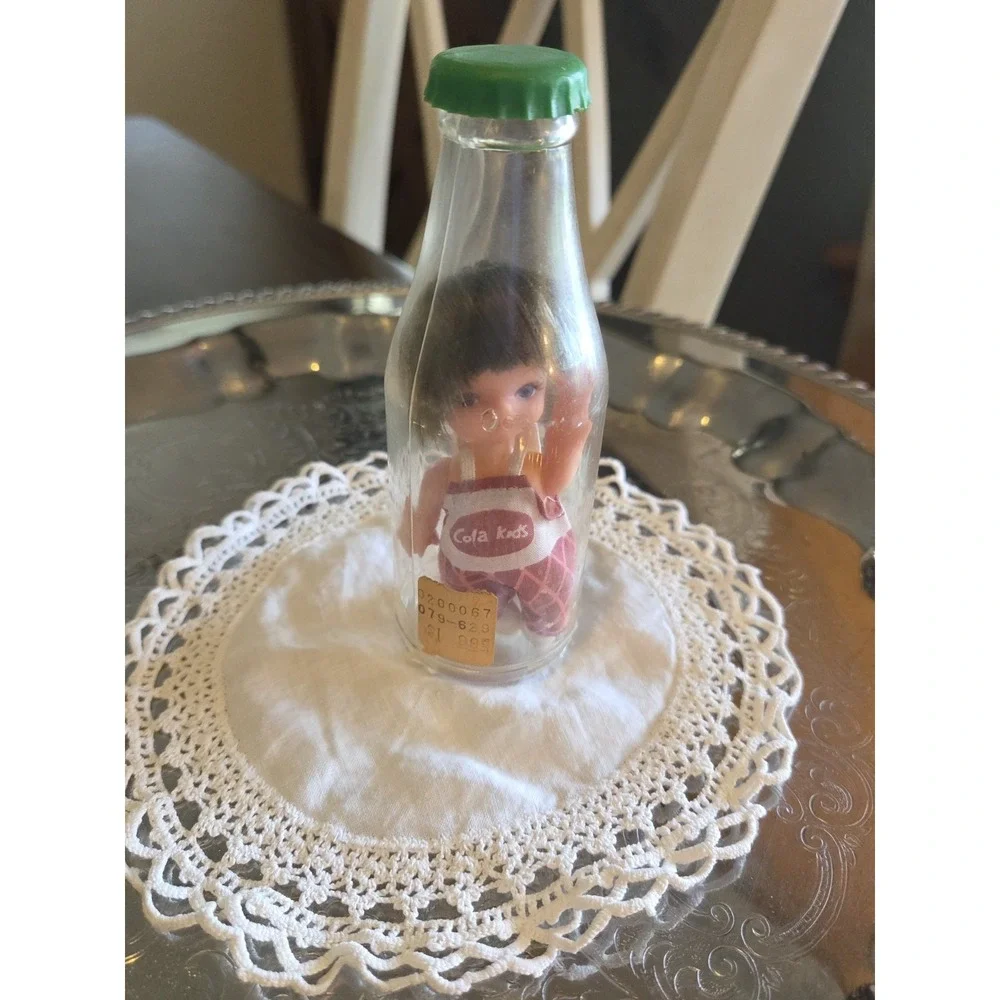 vintage 1960s Cola Kids doll is encased in a clear plastic bottle